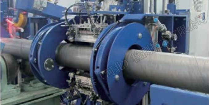 Phased array probe rings enclosing a steel pipe as it advances through the inspection station