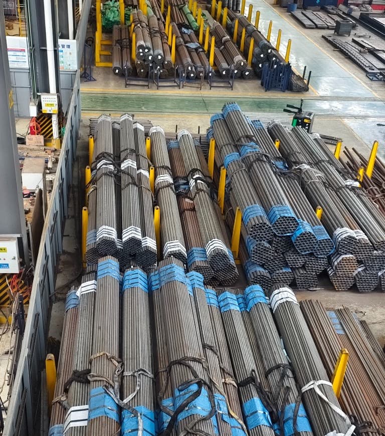 Strapped bundles of small-diameter steel tube racked in the workshop
