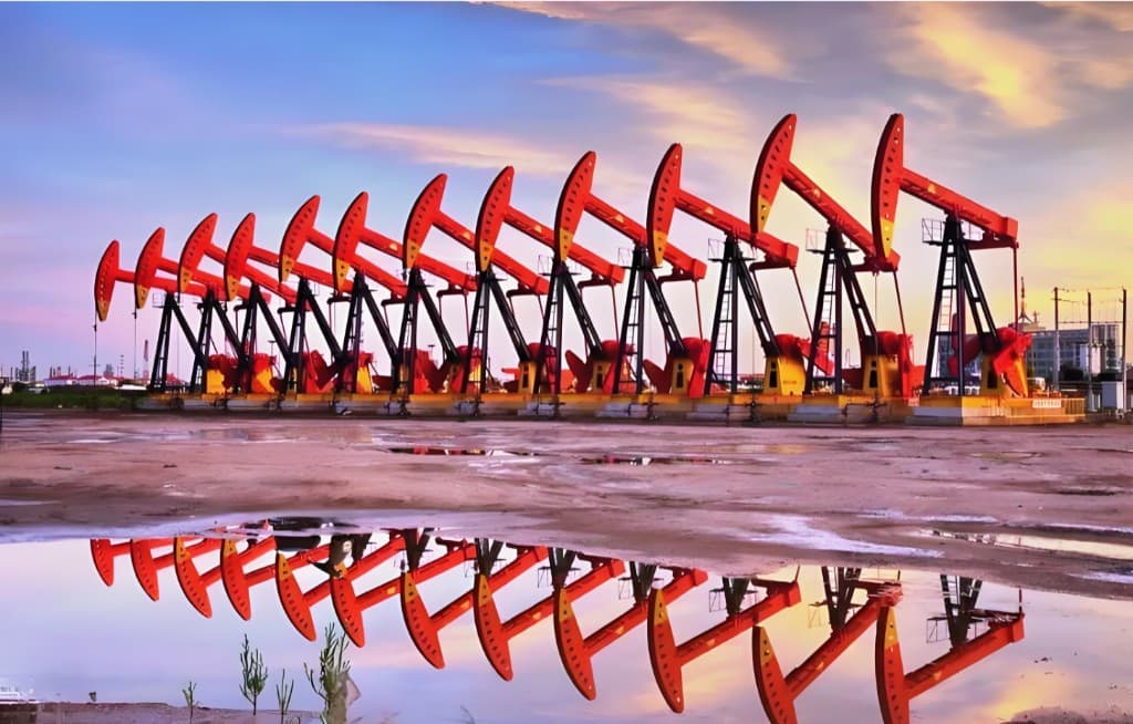Row of oil pumpjacks at a wellsite at dusk