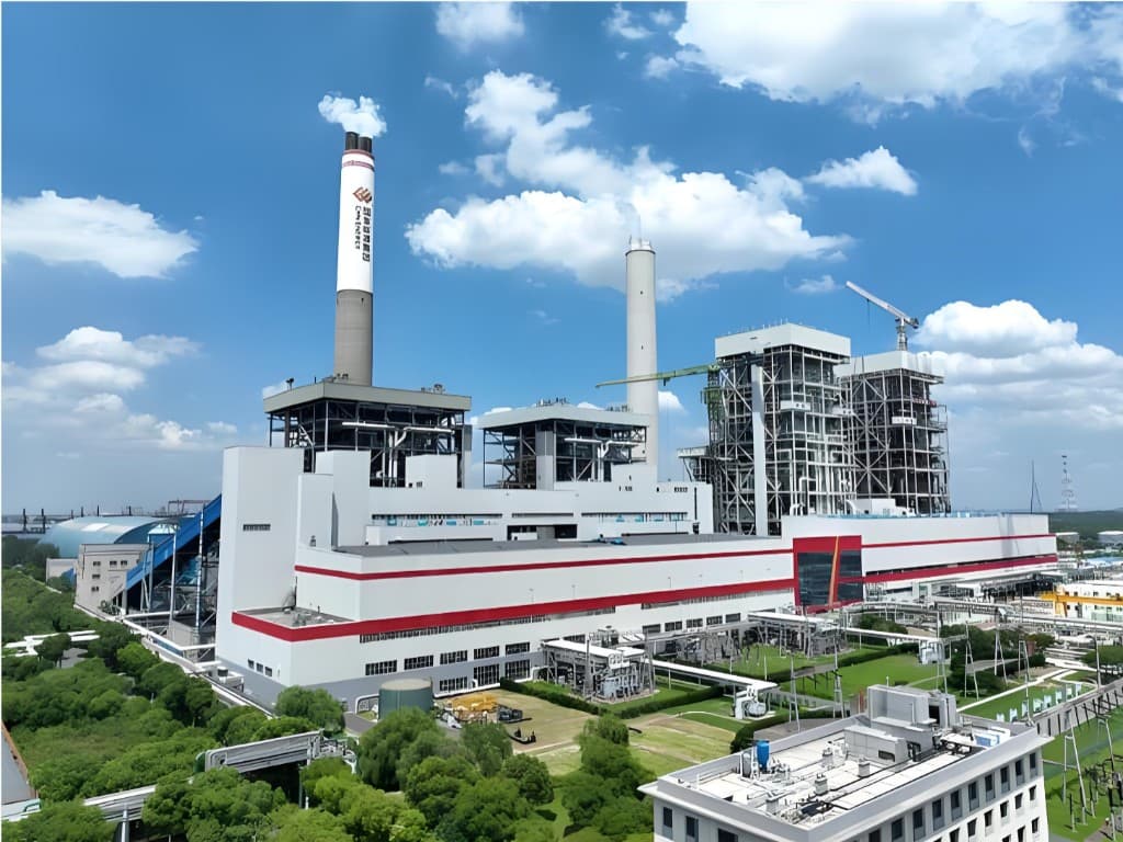 Thermal power plant with chimney stacks under a blue sky
