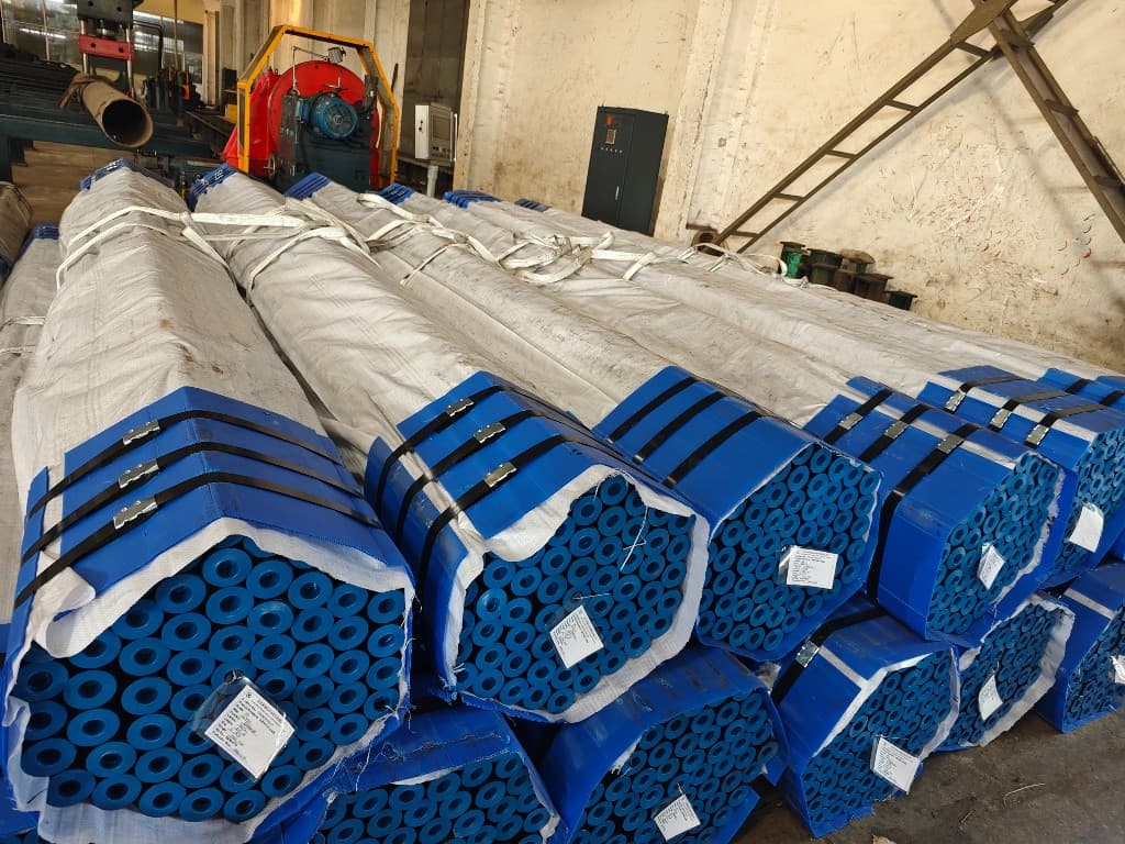 Hexagonal pipe bundles with protective end caps, woven wrap, and steel strapping